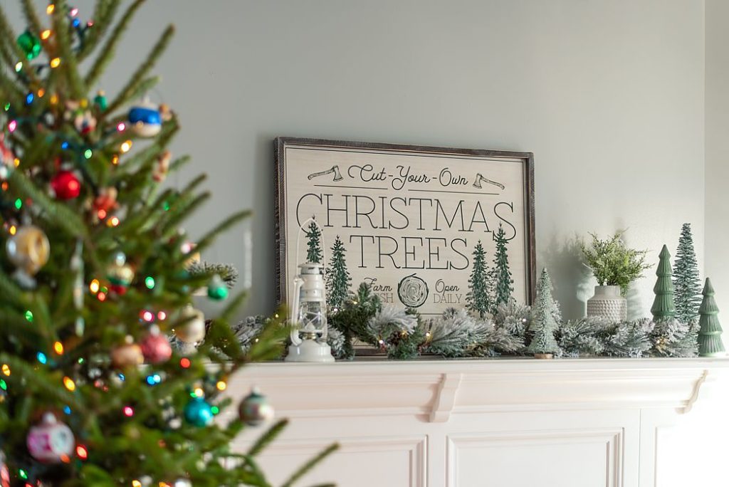 rustic charming mantel with frosted garland and miniature Christmas trees